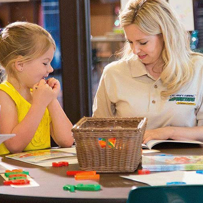 Teacher helping pre-Kindergarten girl